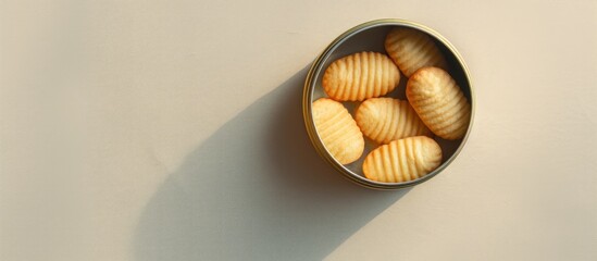 Poster - A top down photograph of a tin can filled with Danish butter cookies captured on a light textured backdrop featuring a copy space image