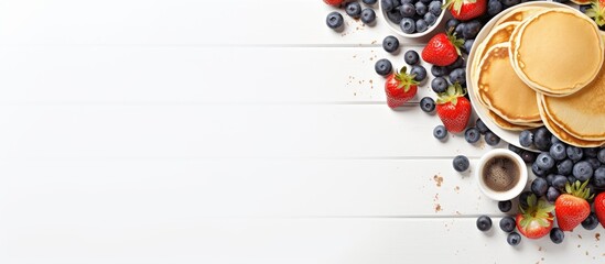 Poster - A trendy breakfast featuring tiny homemade pancakes topped with blueberries and strawberries on a white table The view is from above providing plenty of copy space