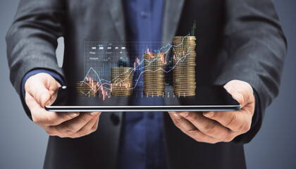 Poster - Close up of male hands holding tablet with growing stacked golden coins with upward diagram. Stock market or forex trading graph and candlestick chart suitable for financial investment concept.