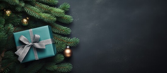 Poster - Top view composition of holiday gifts in a green box intertwined with ropes and a fresh fir tree branch on a festive background offering ample copy space for your message