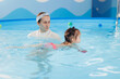 Swimming training for baby girl with trainer in pool. Sport activity for health children concept