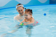 Swimming coach teaches small baby in pool. Sport activity for health children concept.