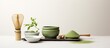 A copy space image featuring matcha powder and tea ceremony tools arranged on a white background