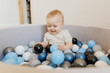 Portrait Happy little boy play in dry pool with colorful balls in living room. Concept lifestyle childhood moment