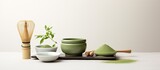Fototapeta Dinusie - A copy space image featuring matcha powder and tea ceremony tools arranged on a white background
