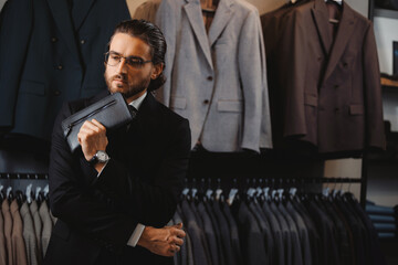 Wall Mural - Portrait business gentleman in glasses and suit buy skin bag in shop store classic clothes