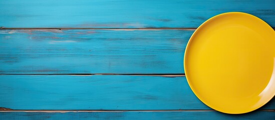 Aufkleber - A copy space image of a yellow plate placed on top of a blue wooden table