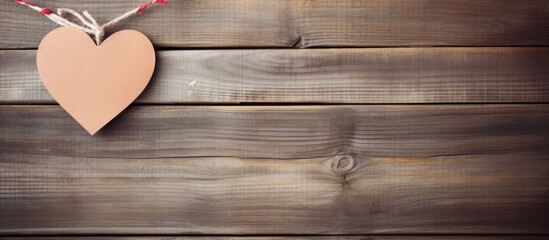 Aufkleber - Copy space image of a paper heart suspended from a clothesline against a rustic wooden backdrop