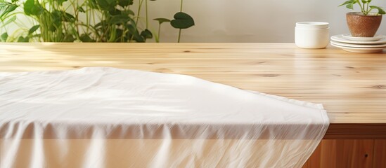 Poster - A light wood countertop covered with a tablecloth adorned with a linen kitchen towel or textile napkin Copy space image