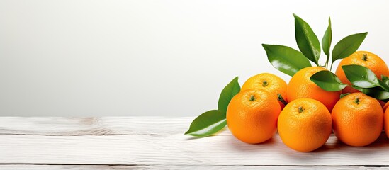 Aufkleber - Seasonal fruits such as vibrant tangerines or clementines abundantly adorned with leaves showcased on a white wooden background creating a refreshing copy space image