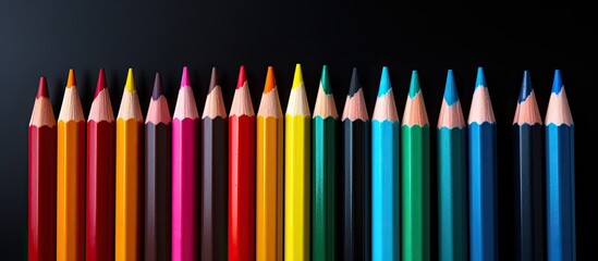 Sticker - A set of colored pencils isolated on a black background perfect for back to school projects with ample copy space image