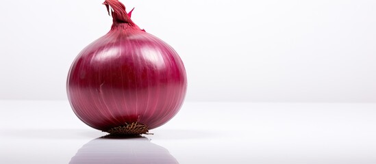Poster - A red onion stands alone on a white background in this copy space image