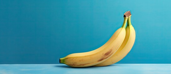 Poster - Studio shot of a banana on a blue background with copy space image