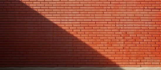 Poster - A textured red brick wall with light and shadow creating an abstract background This copy space image showcases the concept of structure and can be used as a wallpaper
