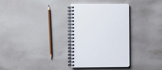 Sticker - Top down view of a gray background showcasing a blank spiral notebook and a pencil accompanied by generous empty space for text input. Creative banner. Copyspace image