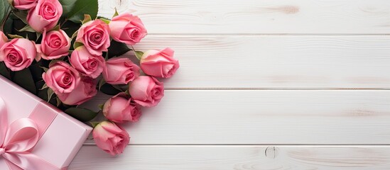 Aufkleber - A top down view of a stunning bouquet of pink roses and a gift wrapped in pink packaging placed on a white wooden surface with ample space for additional images or text