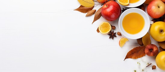 Aufkleber - Top view of a cup of tea adorned with lemon honey autumn leaves and apples placed on a white background This flat lay image captures the essence of autumn with ample copy space for any desired text