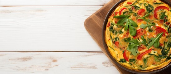 Poster - Top view of a delectable Italian Frittata artfully prepared with spinach tomatoes onion and peppers Beautifully presented on a white wooden table the image showcases a perfect dish Abundant copy spac