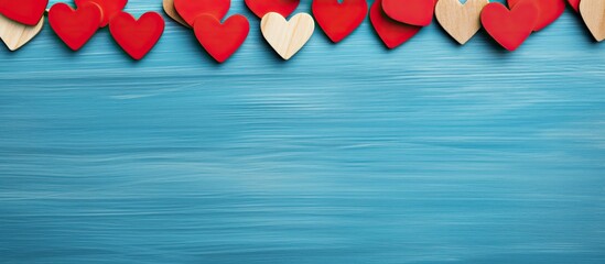 Poster - Valentine s Day decoration wooden clothespin with a red heart on a blue background providing copy space for additional images