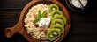 A wholesome breakfast consisting of oatmeal kiwi cottage cheese and raisins is presented on a black plate set against a dark wooden backdrop This image conveys the idea of a healthy breakfast as seen