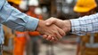 © Elena - Silhouette of two engineers shaking hands and signing a corporate contract outside in front of an oil pump. People in helmets working in the oil field.