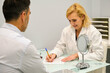 © Ladanifer - Aesthetic doctor woman writing patient personal data on a consent form in a aesthetic clinic.