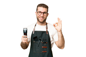 Wall Mural - Barber man in an apron over isolated chroma key background showing ok sign with fingers