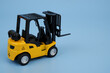 Forklift truck on blue background. Copy space for text.