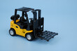 Yellow forklift truck on blue background	