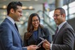 © Elmira - Three professionals engaged in a discussion in an office setting