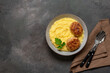 Mashed potatoes with meat cutlet in a bowl on a dark grunge background. Top view, flat lay