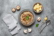 Risotto with mushrooms in a bowl on a gray concrete background. Traditional Italian dish. Top view, flat lay.