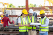 © JU.STOCKER - Engineer and foreman worker team checking project at precast factory site, Engineer and builders in hardhats discussing on construction site