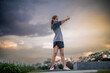 © Anucha - A fit young woman is engaging in warm-up exercises outdoors before her training session at the park.