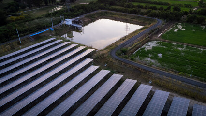 Wall Mural - Aerial view of solar energy panels in the solar farm business of green energy industrial by a drone during the evening with twilightlight.