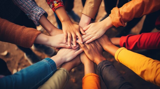 A young people placing their hands together. Friends with stack of hands showing unity and teamwork.