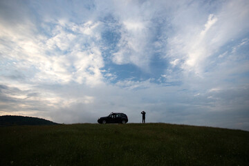 Wall Mural - Active turism. mountain activities concept. Silhouette of a man near his off-road car.