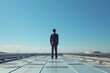 © anatolir - Businessman standing alone on rooftop. Contemplating the city skyline. Reflecting on career. Future. And success with a determined and introspective perspective
