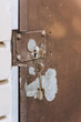 Metal old peeled rusty gate doors with a key in the keyhole. Close-up photography, retro architecture concept.