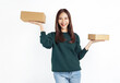 Smiling beautiful Asian woman holding cardboard boxes on white background. Concept delivery online.