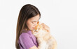 Young Asian woman stands and hugs a sick cat on white background.
