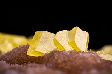 Yellow sulphur crystal on brown calcite. macro photography detail texture background. close-up raw rough unpolished semi-precious gemstone
