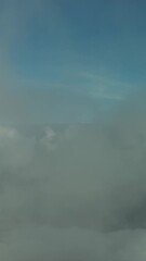 Wall Mural - Flying through beautiful white fluffy clouds between high rocky mountains. Dolomites Alps mountains, Italy. Vertical video