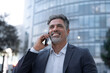 © Stock 4 You - Successful mid age man investor communicating on smartphone standing at busy street. Mature confident businessman entrepreneur using cellphone mobile phone for talking with client, business partners