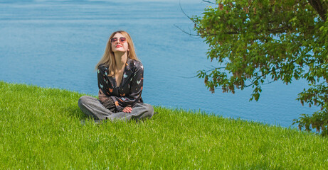 Energy healing and meditation concept, woman on a grass chilling and resting outside