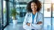 © Tanya - Confident African American female doctor in lab coat and stethoscope in modern bright hospital. Medicine, healthcare, profession concept.