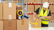Man packer in warehouse. Storekeeper seals box with tape. Packer works in distribution center. Male uses tape dispenser. Boxes on racks around storekeeper. Man packer in yellow vest