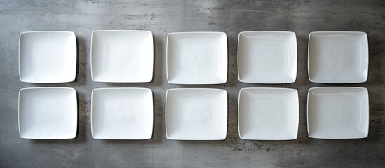 Wall Mural - Horizontal top view of empty plates on a grey cement background with white napkins providing a clean and visually appealing copy space image