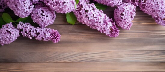Wall Mural - A flat lay floral arrangement with fresh lilac flowers on a wooden background allowing for copy space in the image
