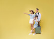© NaMong Productions - Happy fun asian family vacation portrait. Father, mother and daughters pointing finger copy space ready for travel flight isolated on yellow background.